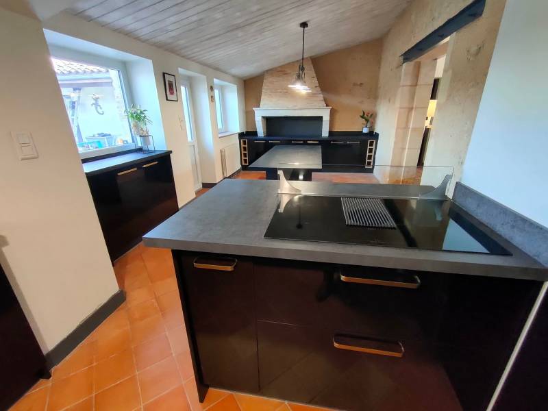 Réalisation cuisine laquée noire et bois avec ilôt centrale et plaque aspiranteà Saint Morillon