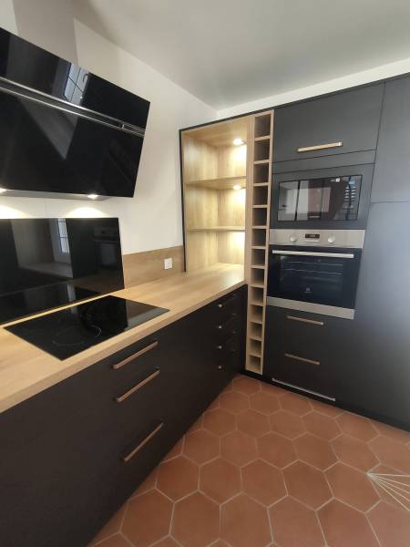 Cuisine noire mat et bois avec casier range bouteilles et niches ouvertes à Portets