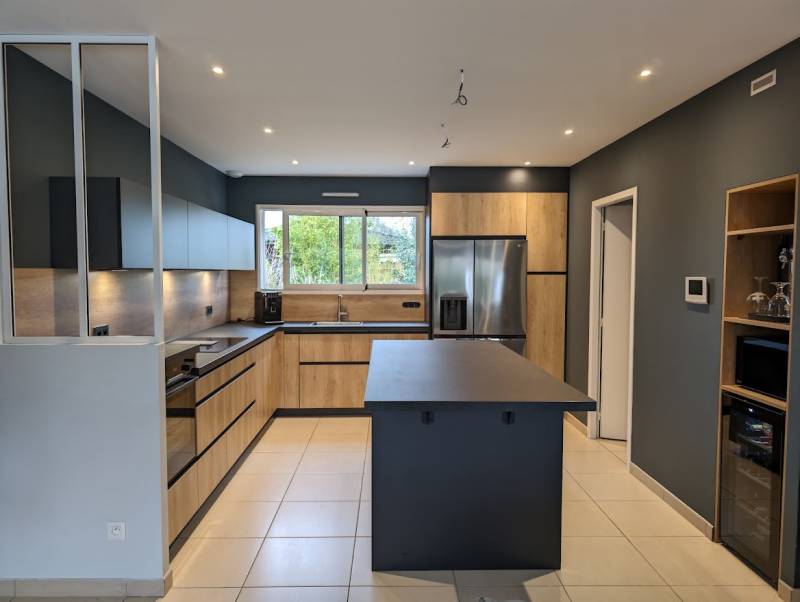 Réalisation d'une cuisine noire et bois avec façades coloris chêne naturel et bois, poignées prises de main noires, plinthes noires, plan de travail noir Zimbabwé et niche ouvertes à Saint Selve