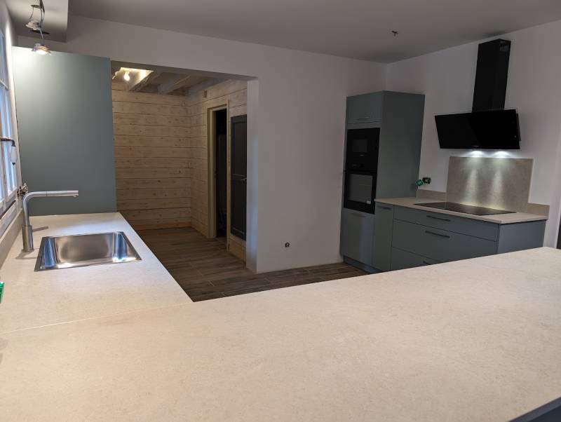 Cuisine avec frigo encastré dans le mur avec hotte noire à La Brède