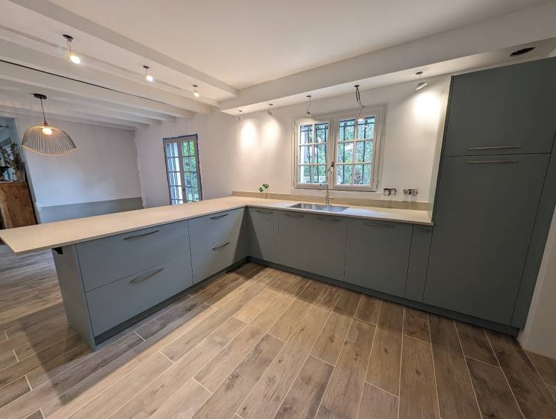 Cuisine en L gris vert avec plan de travail beige et grand évier à La Brède