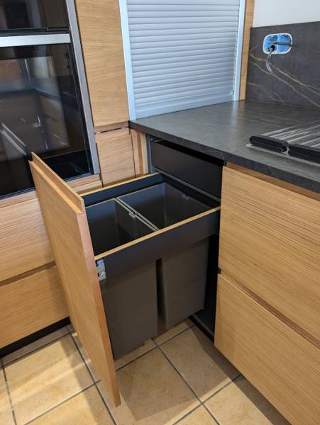 Cuisine noire et bois : cuisine sur mesure en placage bois massif, poignée à gorge et plan de travail en pierre céramique colori Noir Dekton Laurent à Saint Morillon