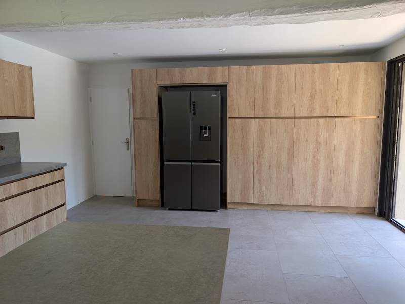 Cuisine avec plusieurs armoires sans poignées colori bois clair et profil bronze à Rions