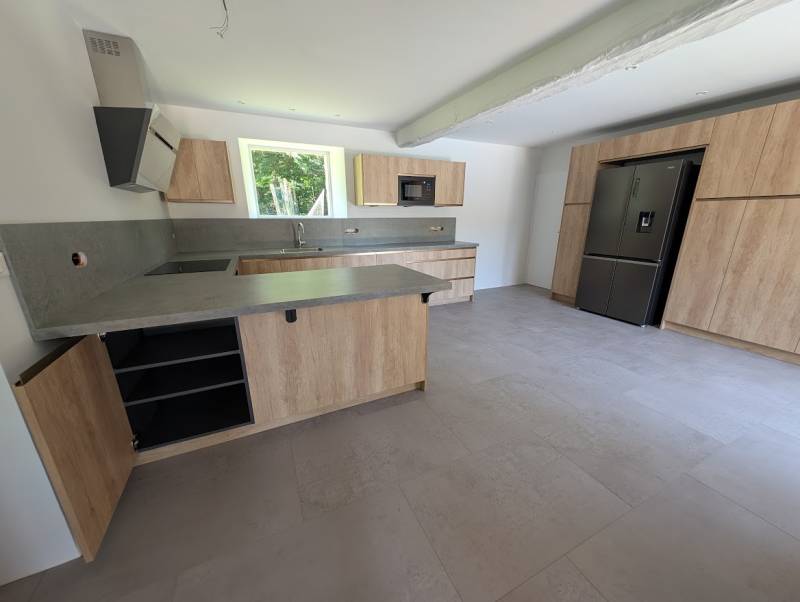 Cuisine sur mesure à Rions:  couleurs bois clair sans poignées et plan de travail et céramique gris clair