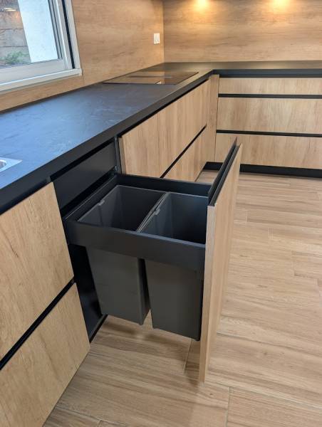 Tri sélectif parfaitement intégré : une fonctionnalité indispensable de notre cuisine sur mesure noire et bois.