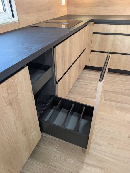 Robustesse et élégance : plan de travail en stratifié 39mm colori Ardoise Moon contrastant avec la façade chêne naturel de cette cuisine.