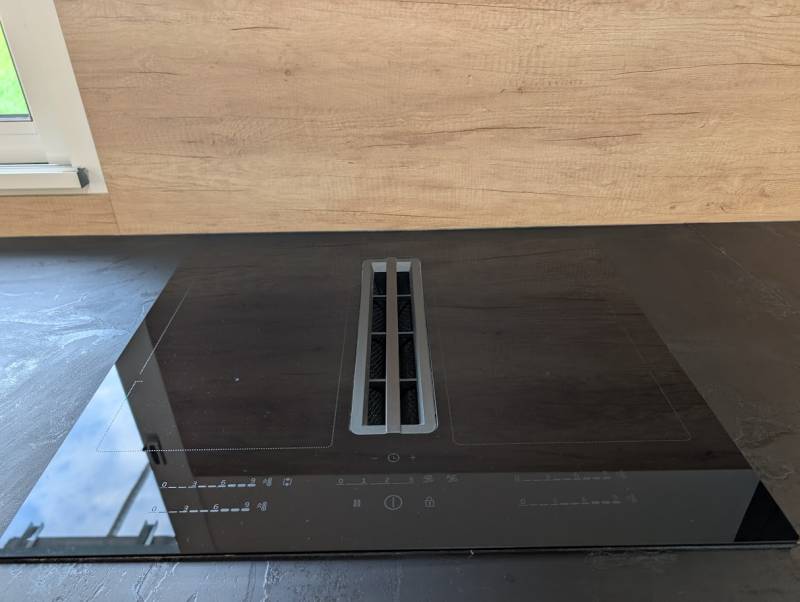 Rangement intelligent sous l'évier avec tiroirs profonds, mis en valeur par la poignée profils noir mat de cette cuisine sur mesure.