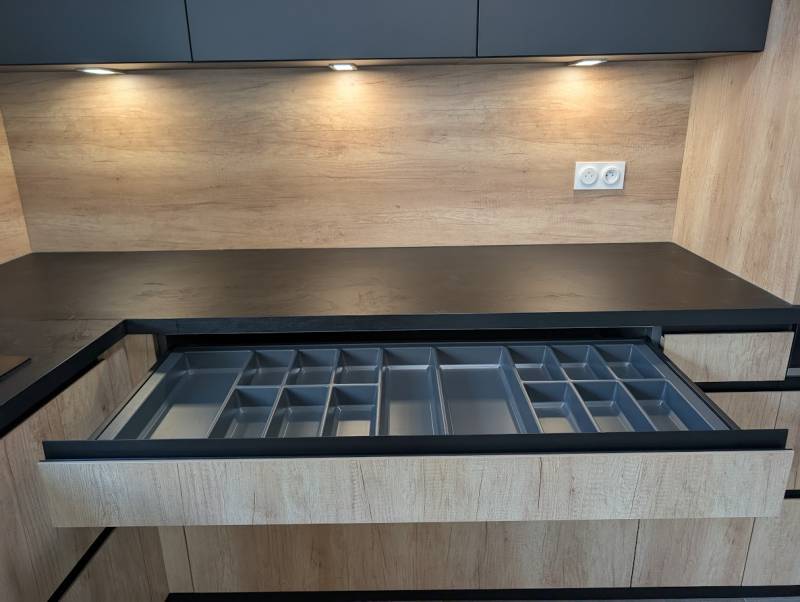 Organisation optimisée : tiroir à couverts et tiroir à l'anglaise noir pour cette cuisine sur mesure de cuisiniste sur mesure de qualité.