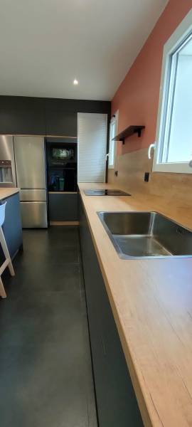 Cuisine anthracite et peche abricot à La Brède avec plan de travail bois