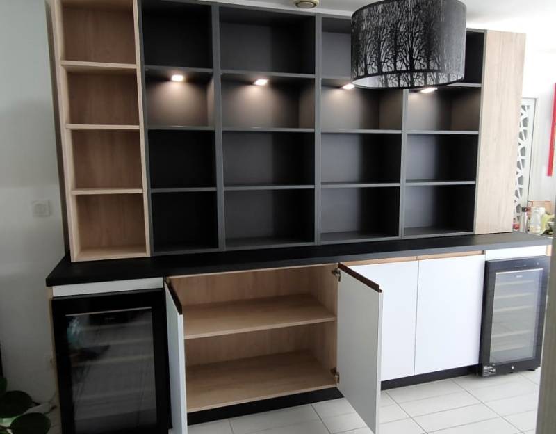 Création d'un espace cave à vin assorti à une cuisine sur mesure blanc mat et profil bronze avec lumières intégrées à Martillac